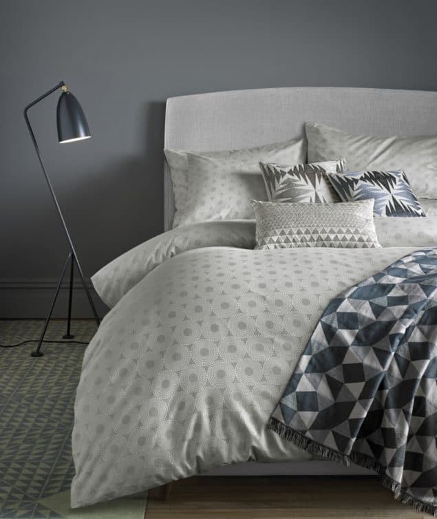 Contemporary bedroom featuring a cosy bed made up with silver geometric bedding from Niki Jones