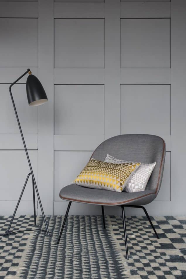 Chair and floor lamp placed on a grey geometric rug by Niki Jones