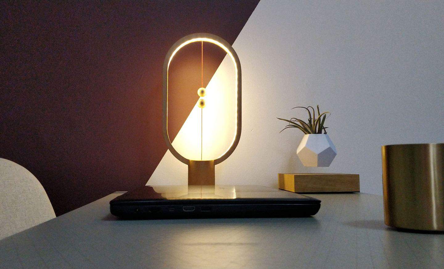 Heng Balance Lamp by Enso & Paris on a desk behind a laptop