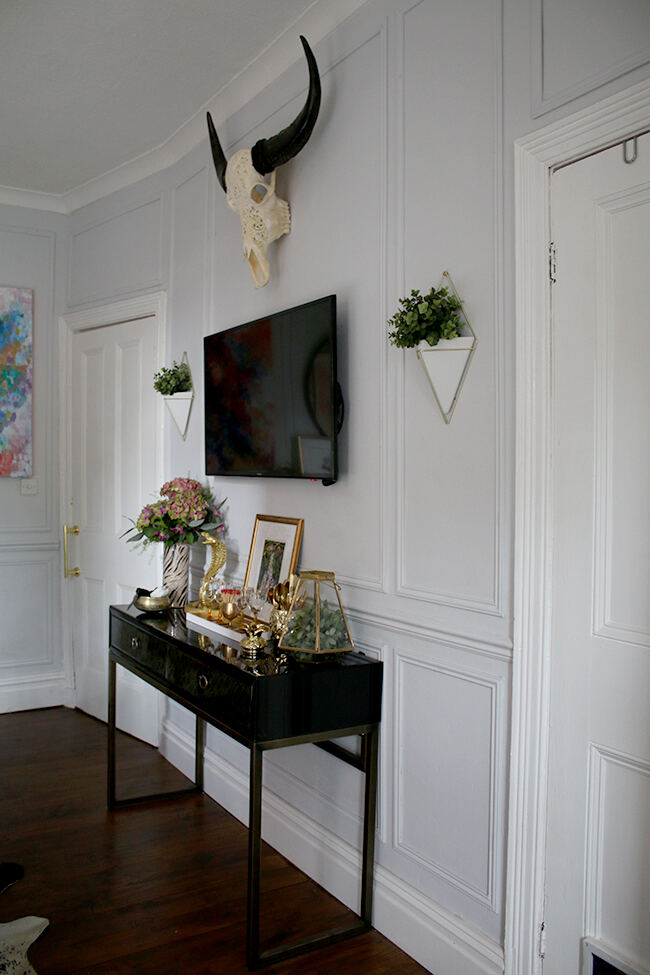 wooden panelling created by afixing moulding to the wall of this grey dining room