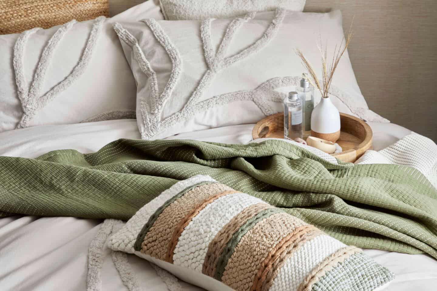 Interior Trends for 2022: Organic Minimalism. The Edited Life Collection from Dunelm. An unmade double bed covered in highly textured blankets and cushions