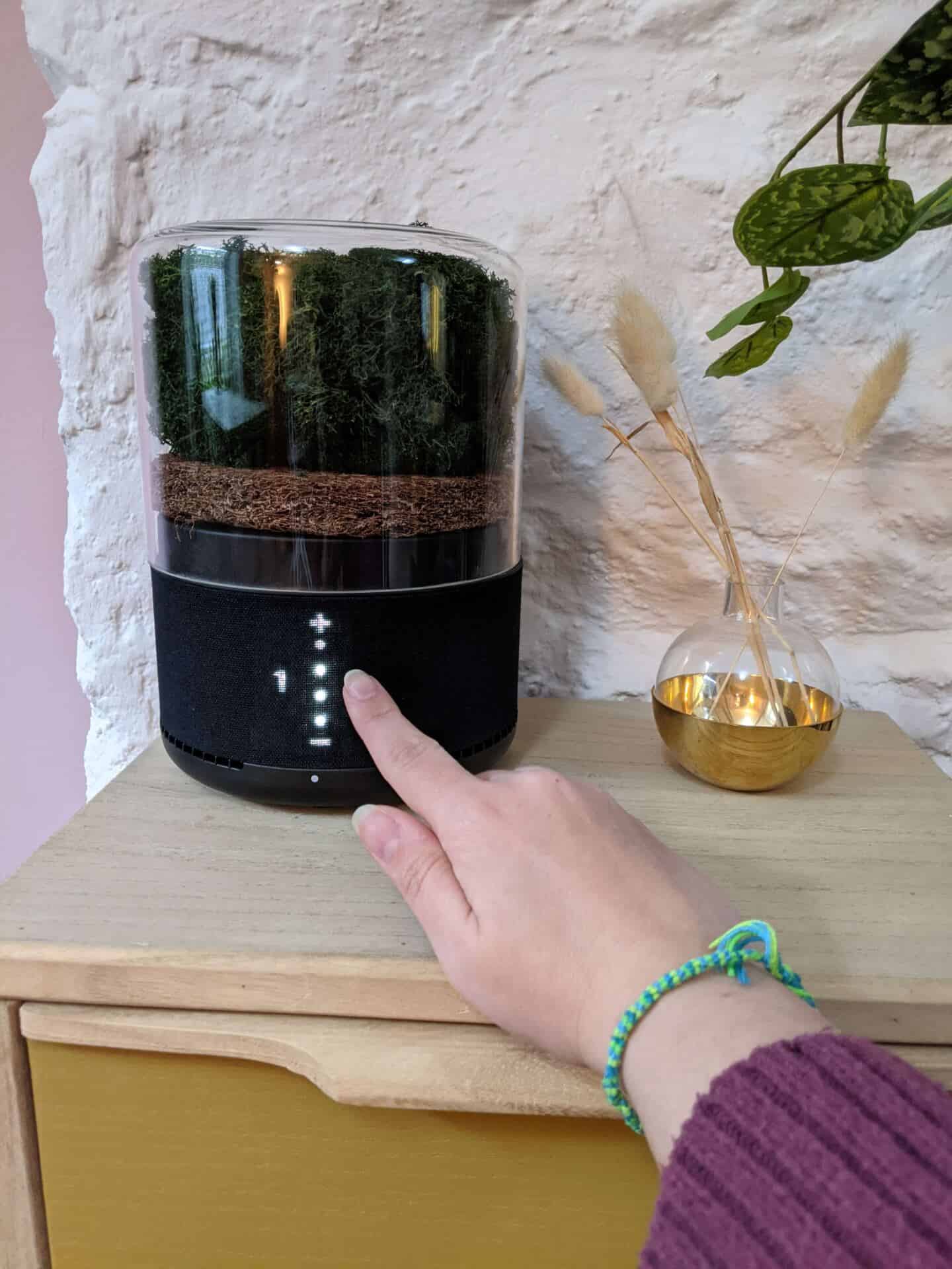 a hand activates the touch sensor of the briiv air purifier
