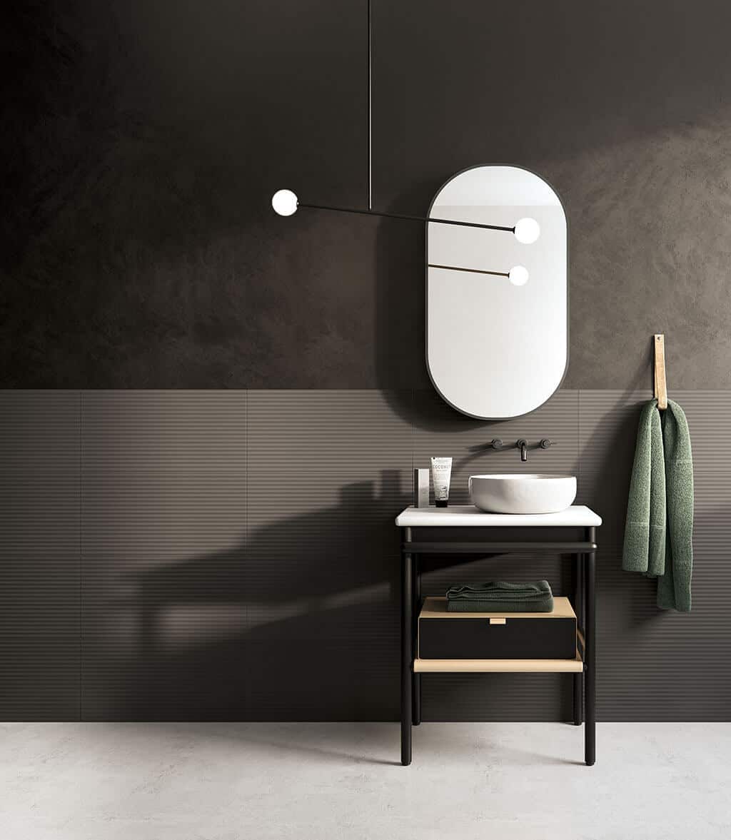 Linea Grafite textured wall tiles from European Heritage used in a bathroom behind a small console with basin on top and curved mirror above