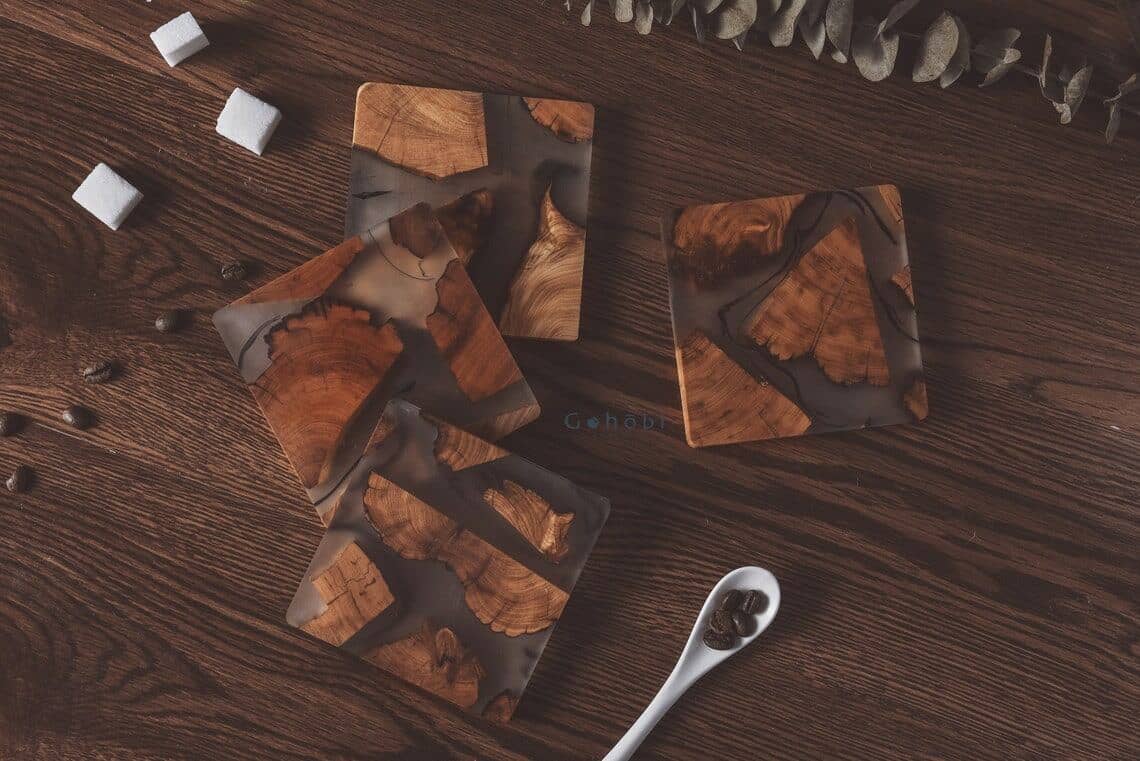 wood and resin coaster set on a wooden surface with sugar cubes and coffee beans scattered around