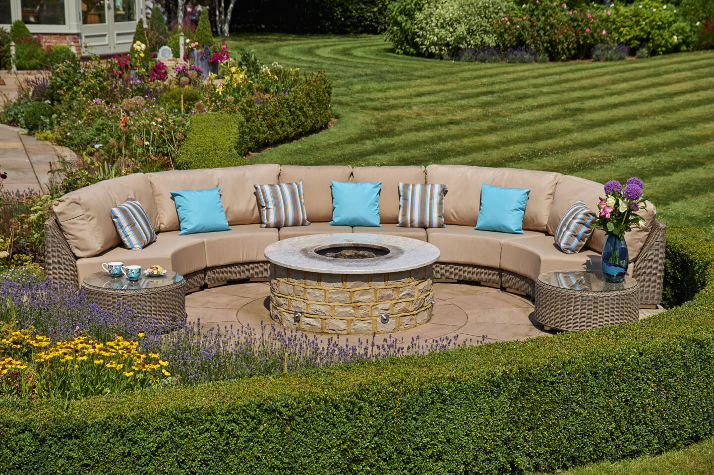 curved garden sofa positioned around a fire pit in a garden.