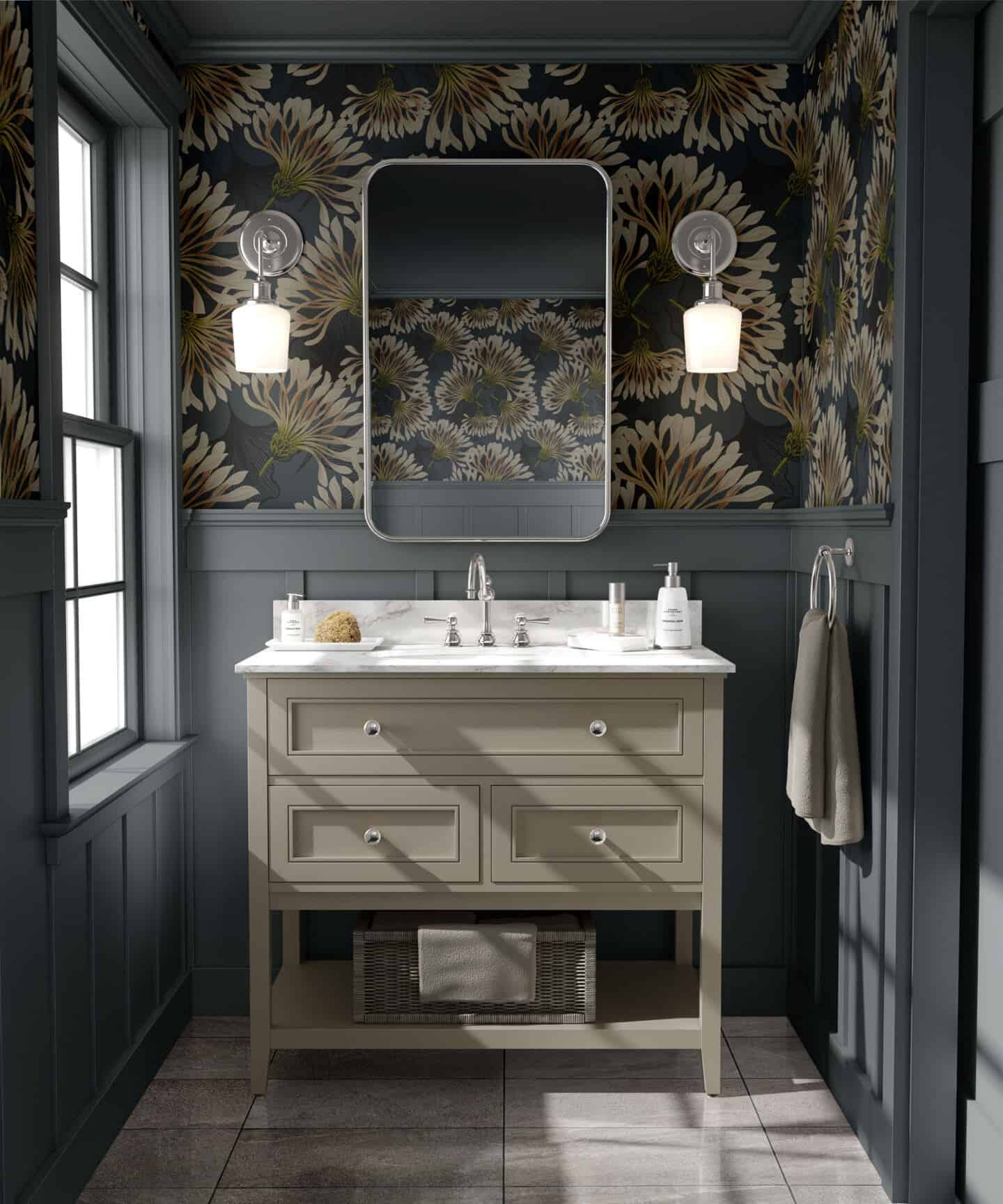 A washbasin with mirror above in a grey bathroom with wall panelling on the lower half of the wall and botanical wallpaper above. 
