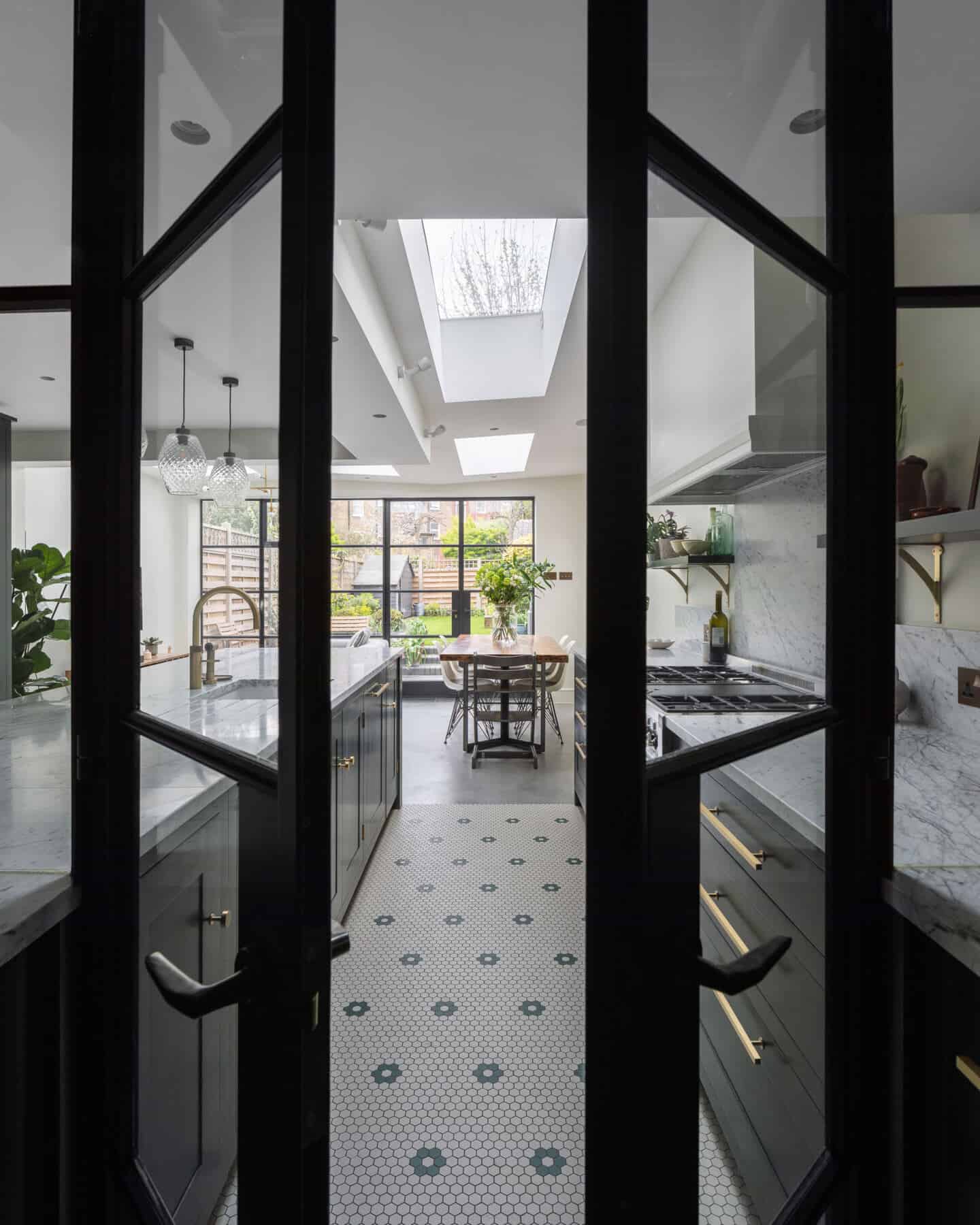 A view of a kitchen through to a dining area and out to the garden