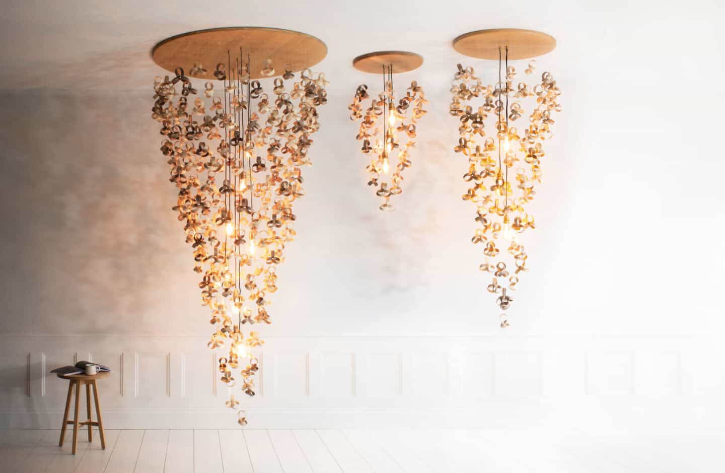 Three wooden chandeliers in varying sizes hang from the ceiling