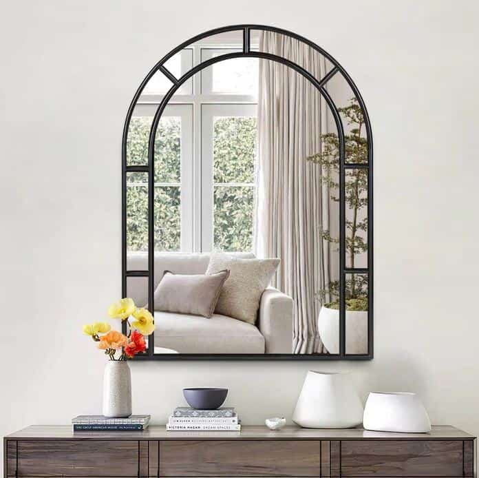 A small arched mirror from neutypechic wall-mounted above a sideboard 