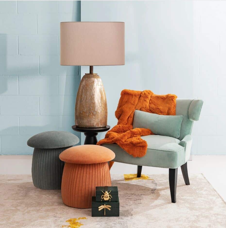 A green and orange mushroom pouffe in front of a green armchair