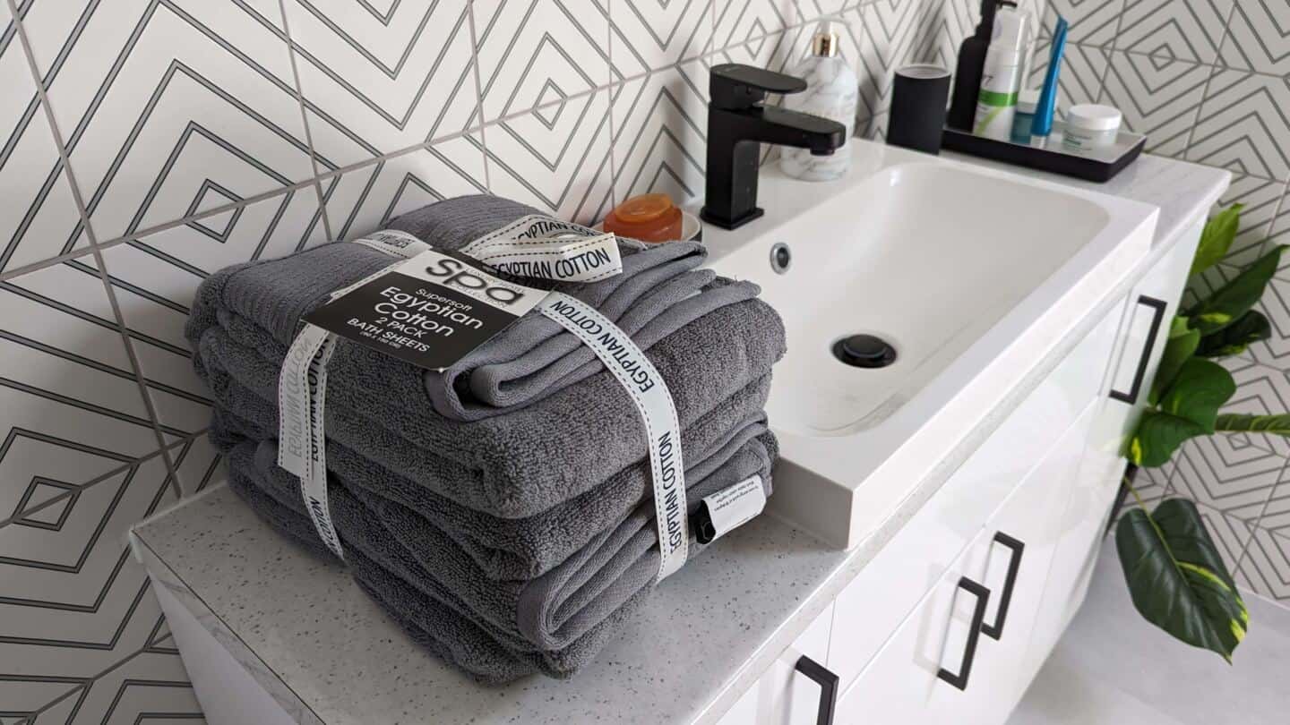 Grey Egyptian Cotton Bath Towel Bale next to a sink on a vanity unit in a bathroom