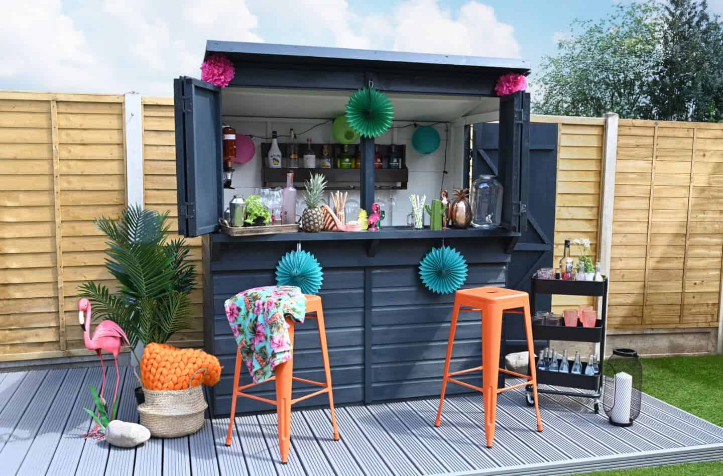 A garden shed painted black and used as a garden bar