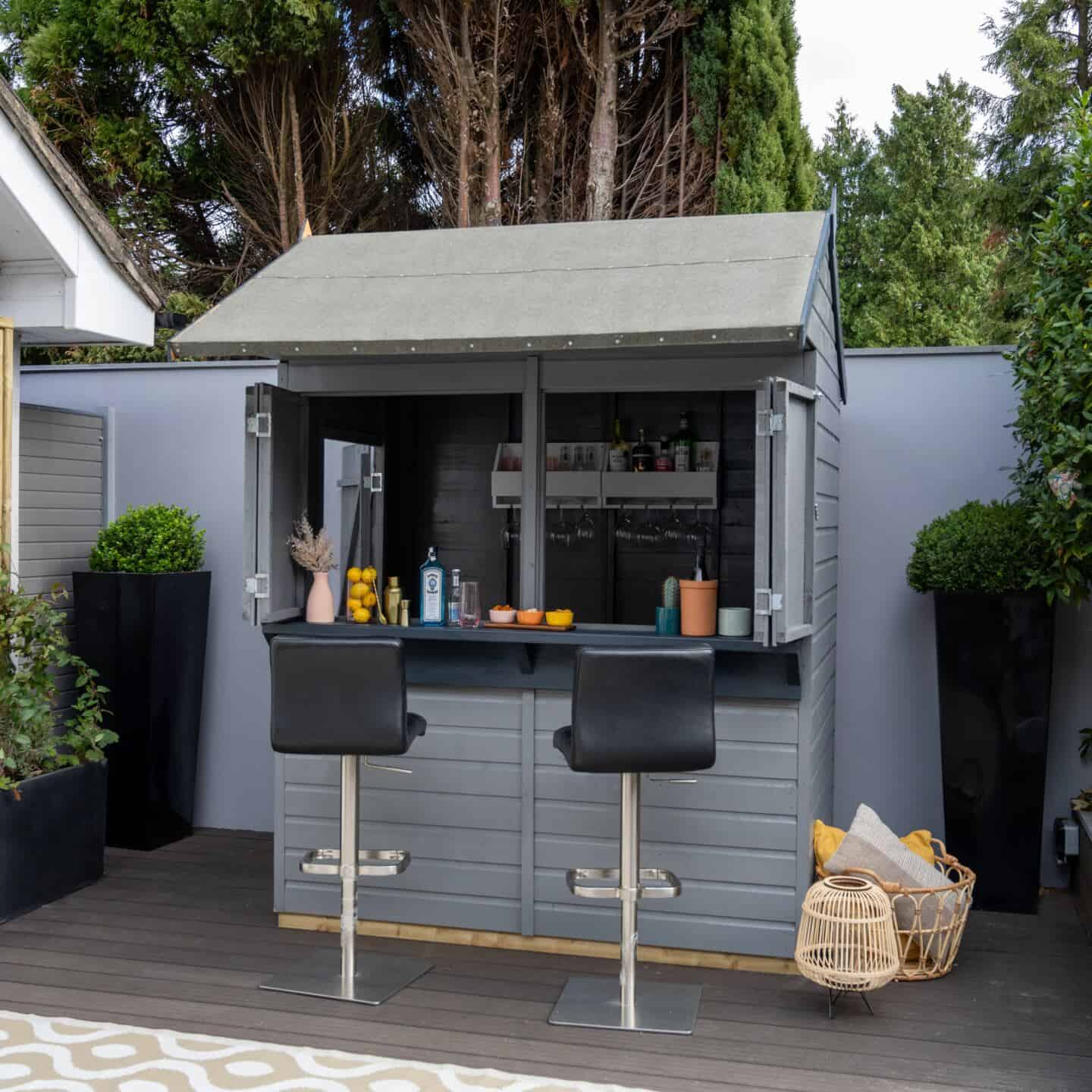 A garden shed painted grey and used as a bar
