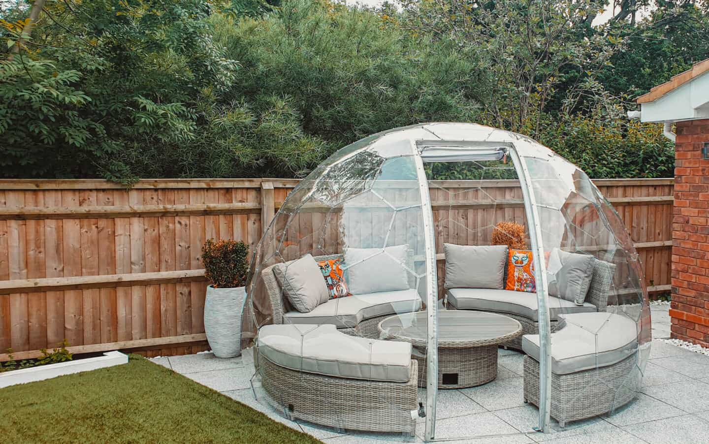Curved garden lounge set inside a garden dome on a patio