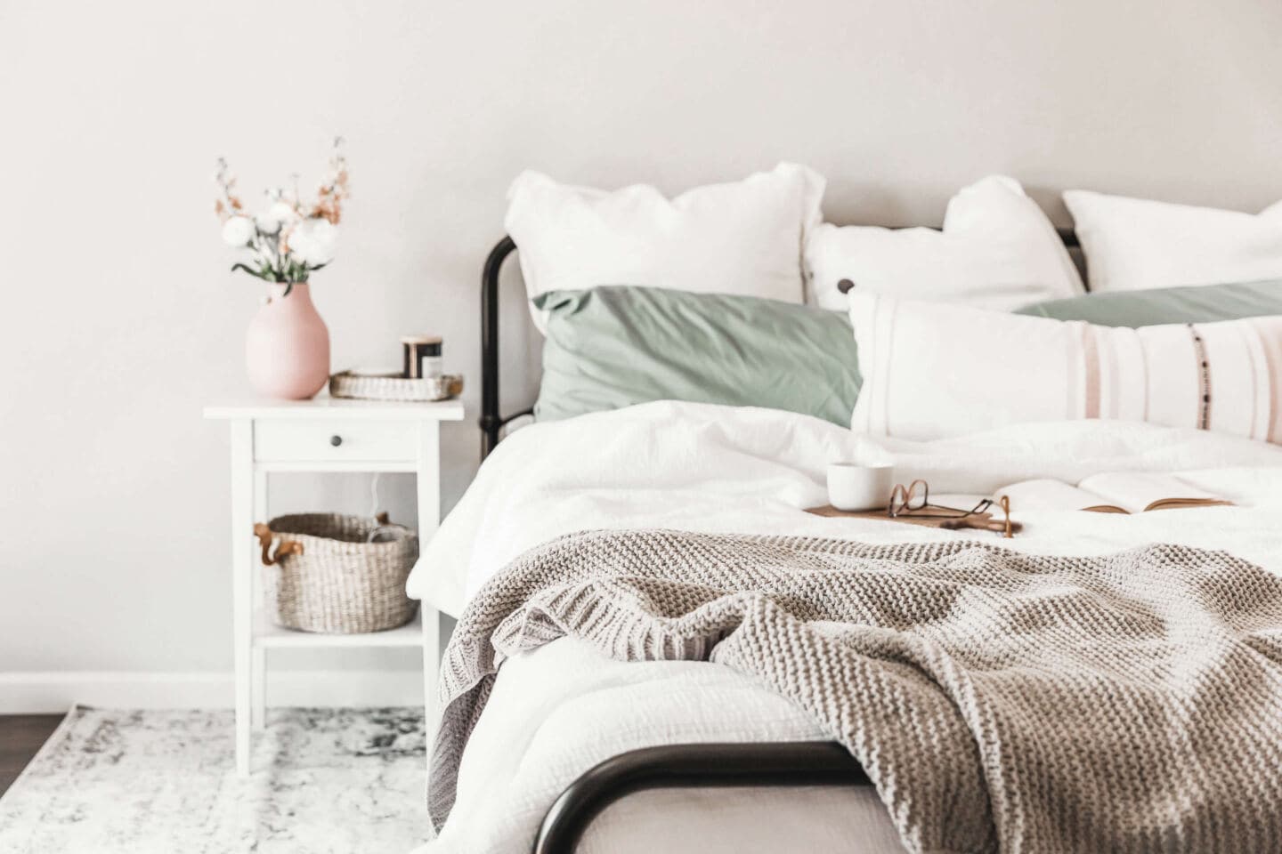 A serene bedroom featuring a bed layered with textured bedding in muted colours