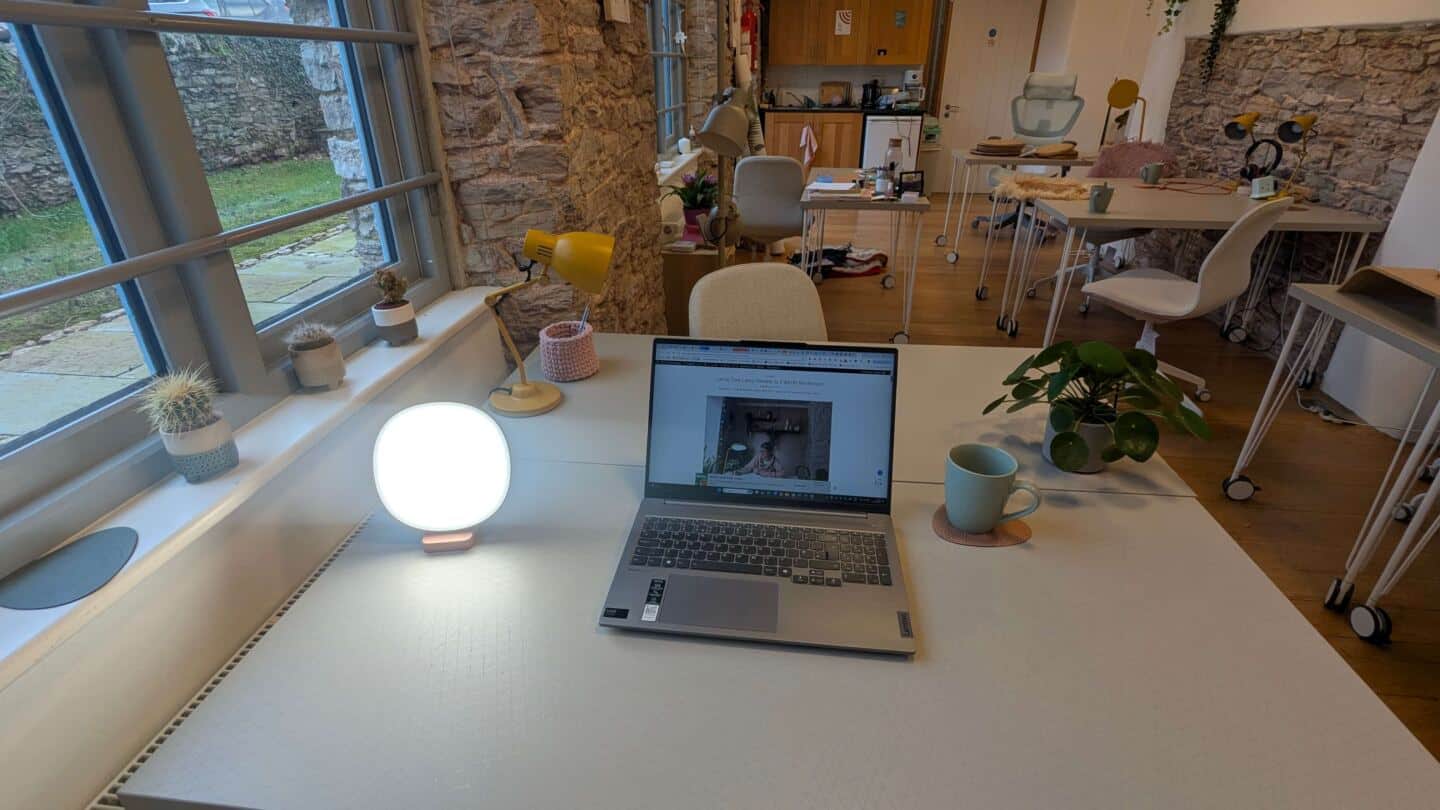 Lumie Dash Sad Lamp on a desk next to an open laptop in a coworking space for women in Totnes